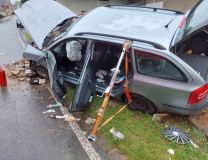 Auto nárazem částečně zbořilo betonový plot u rodinného domu, cestující utrpěl zranění