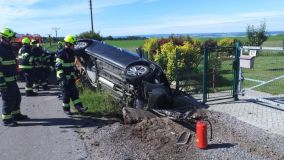 Jedno vozidlo skončilo na střeše v poli, druhé zastavilo o konstrukci mostku na boku
