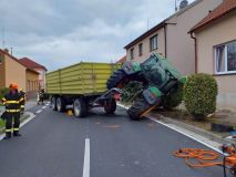 Traktor s přívěsem za sebou se převrátil na bok a zatarasil celou vozovku