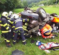 Auto se střetlo s vlakem, skončilo zmuchlané na louce, řidičku hasiči vyprošťovali