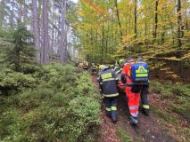 Muž spadl ze skály, měl silné bolesti zad. K sanitce ho nesli hasiči kus nepřístupným terénem