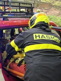 Muž spadl ze skály, měl silné bolesti zad. K sanitce ho nesli hasiči kus nepřístupným terénem