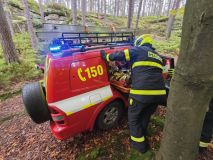 Muž spadl ze skály, měl silné bolesti zad. K sanitce ho nesli hasiči kus nepřístupným terénem