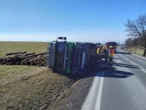 Obrazem: Plně naložený nákladní automobil se sdřevem si lehnul na bok a dřevo se rozsypalo kolem