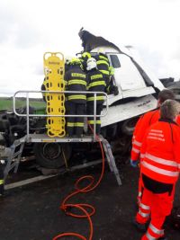 Dvě nákladní auta se střetla v Janově, jedno z nich začalo hořet. Řidiče museli hasiči z kabiny vyprošťovat. Na místě zasahoval i vrtulník