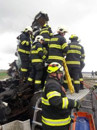 Dvě nákladní auta se střetla v Janově, jedno z nich začalo hořet. Řidiče museli hasiči z kabiny vyprošťovat. Na místě zasahoval i vrtulník