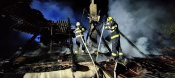 Dům plný nepořádku a obrostlý zelení postihl požár. Hasiči si museli cestu prosekat motorovou pilou