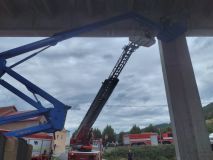 Dělníci uvízli ve výšce pod mostem na plošině, která se zasekla o pilíř