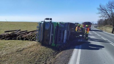 Obrazem: Plně naložený nákladní automobil se sdřevem si lehnul na bok a dřevo se rozsypalo kolem