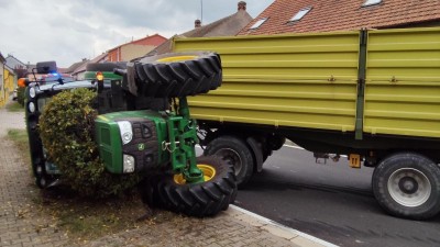 Traktor s přívěsem za sebou se převrátil na bok a zatarasil celou vozovku