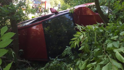 Tři zásahy hasičů v neděli odpoledne: Vzňalo se plně obsazené auto, hořelo v bytě a vůz skončil na boku v porostu