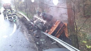 Nákladní auto převážející asfalt se převrátil na střechu do příkopu v blízkosti potoka
