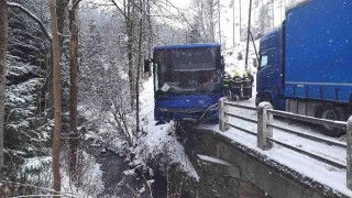 Obrazem: Autobus se střetl s kamionem a zůstal viset z mostku nad potokem. Lidé vystupovali oknem