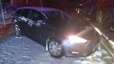 Řidič při otáčení auta na zamrzlé silnici skončil u svodidel, klouzalo to i hasičům, volali silničáře